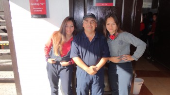 Don Luis, auxiliar de nuestro colegio, recibiendo el aprecio de dos alumnas.